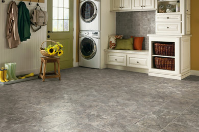 Example of a mid-sized transitional gray floor laundry room design in Detroit with raised-panel cabinets, white cabinets, yellow walls and a stacked washer/dryer