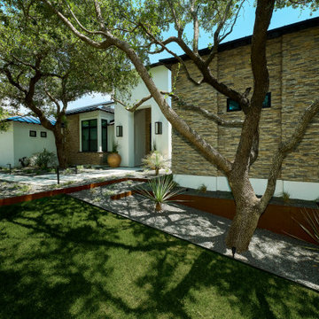Contemporary home exterior with white stucco and dry stack stone