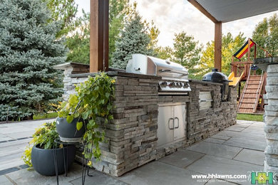 Inspiration for a large traditional partial sun backyard stone landscaping in Omaha with a fire pit for summer.