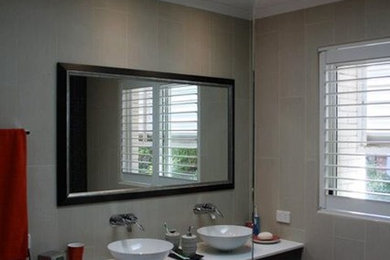 This is an example of a large asian master bathroom in Brisbane with a vessel sink, flat-panel cabinets, grey cabinets, engineered quartz benchtops, an open shower, a wall-mount toilet, beige tile, porcelain tile, beige walls and porcelain floors.