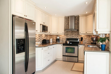 Inspiration for a mid-sized transitional u-shaped porcelain tile and beige floor enclosed kitchen remodel in Toronto with a double-bowl sink, raised-panel cabinets, white cabinets, quartz countertops, multicolored backsplash, matchstick tile backsplash, stainless steel appliances, no island and gray countertops