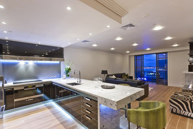 Minimalist kitchen photo in New York with an integrated sink, stainless steel countertops, metallic backsplash and stainless steel appliances