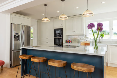 Design ideas for a traditional kitchen in Surrey with quartz worktops, an island and white worktops.