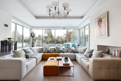 Mid-sized contemporary enclosed living room in London with white walls, light hardwood floors, no fireplace and no tv.