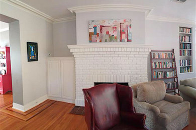 Example of a mid-sized transitional formal and enclosed medium tone wood floor living room design in Charlotte with gray walls, a standard fireplace and a brick fireplace