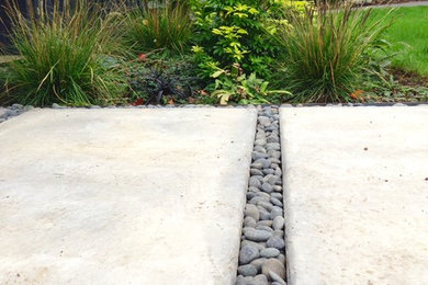 Photo of a mid-sized midcentury front yard partial sun xeriscape in Portland with concrete pavers.