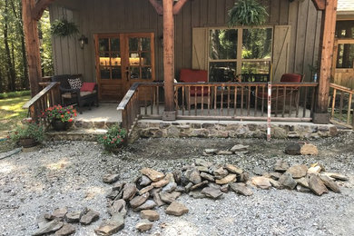 Inspiration for a rustic front yard stone landscaping in Other.