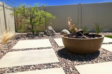 Photo of a mid-sized contemporary drought-tolerant and full sun backyard concrete paver landscaping in Los Angeles with a fire pit.