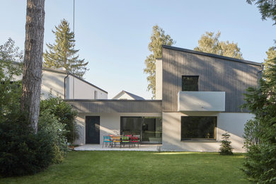 Modernes Reihenhaus mit grauer Fassadenfarbe, Blechdach und Verschalung in München