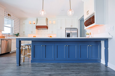 Eat-in kitchen - mid-sized coastal l-shaped laminate floor and gray floor eat-in kitchen idea in Orlando with an undermount sink, shaker cabinets, white cabinets, quartz countertops, blue backsplash, marble backsplash, stainless steel appliances, a peninsula and white countertops