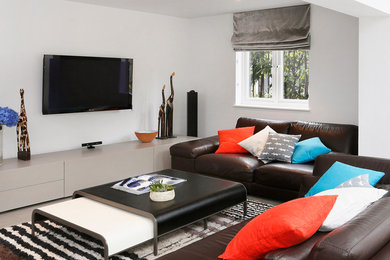 This is an example of a contemporary open concept living room in London with grey walls, porcelain floors and a wall-mounted tv.