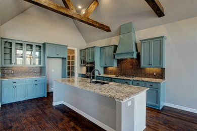 Mid-sized transitional l-shaped dark wood floor eat-in kitchen photo in Other with a double-bowl sink, recessed-panel cabinets, blue cabinets, glass countertops, brown backsplash, cement tile backsplash, stainless steel appliances and an island