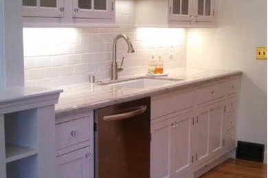 Example of a transitional medium tone wood floor eat-in kitchen design in San Francisco with beaded inset cabinets, white cabinets, a drop-in sink, granite countertops, white backsplash, subway tile backsplash and stainless steel appliances