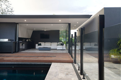 This is an example of a small contemporary front yard rectangular pool in Melbourne with a pool house and tile.
