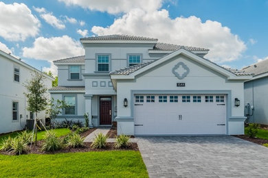 Large beach style gray two-story stucco house exterior photo in Other with a hip roof and a tile roof