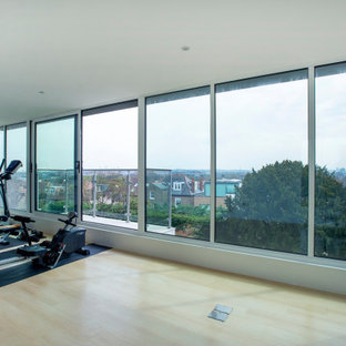 Foto di una grande palestra multiuso design con pareti bianche, pavimento in laminato e pavimento giallo