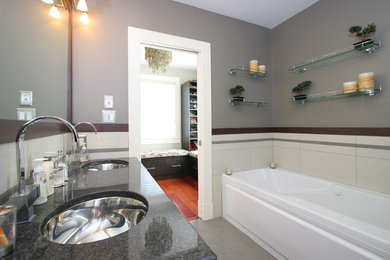 Inspiration for a mid-sized transitional master bathroom in Boston with an alcove tub, grey walls, an undermount sink, porcelain floors, grey floor, flat-panel cabinets and black cabinets.