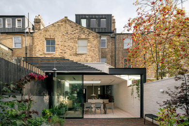 This is an example of a white contemporary brick and rear house exterior in London.