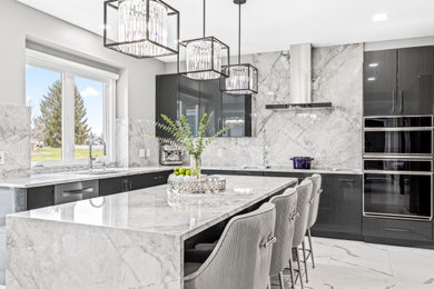 Large trendy u-shaped porcelain tile and white floor eat-in kitchen photo in Detroit with flat-panel cabinets, gray cabinets, marble countertops, white backsplash, marble backsplash, stainless steel appliances, an island and white countertops