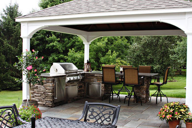 Large traditional backyard patio in Philadelphia with natural stone pavers.