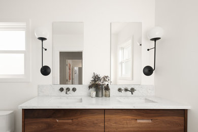 Inspiration for a mid-sized 1950s master marble tile porcelain tile, brown floor and double-sink shower bench remodel in San Francisco with flat-panel cabinets, dark wood cabinets, a one-piece toilet, white walls, an undermount sink, a hinged shower door and a floating vanity