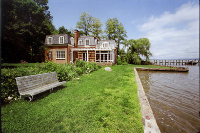 Example of a mid-sized farmhouse beige two-story stucco exterior home design in New York