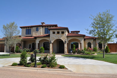 Design ideas for a large mediterranean two-storey beige exterior in Austin with stone veneer and a hip roof.