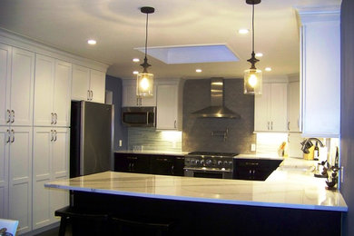 Eat-in kitchen - mid-sized contemporary u-shaped dark wood floor eat-in kitchen idea in New York with a farmhouse sink, shaker cabinets, dark wood cabinets, quartz countertops, white backsplash, glass tile backsplash, stainless steel appliances and a peninsula