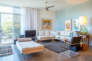 Example of a trendy open concept concrete floor and gray floor living room design in Other with blue walls and a tv stand