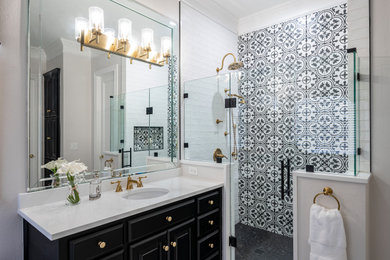 ダラスにあるトランジショナルスタイルのおしゃれなマスターバスルーム (白いキャビネット、アルコーブ型シャワー、モノトーンのタイル、開き戸のシャワー、ニッチ、洗面台1つ、造り付け洗面台) の写真