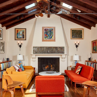 Inspiration for an eclectic medium tone wood floor and brown floor living room remodel in San Francisco with white walls and a standard fireplace