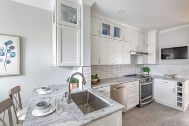 Small transitional u-shaped porcelain tile and gray floor enclosed kitchen photo in Boston with an undermount sink, shaker cabinets, white cabinets, quartz countertops, gray backsplash, ceramic backsplash, stainless steel appliances and gray countertops