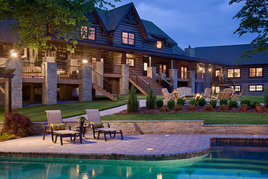 Inspiration for a large rustic backyard concrete paver and custom-shaped hot tub remodel in Other