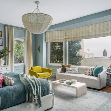 Primary Bedroom with Light Blue Walls, Yellow Accents, and Layered Bedding