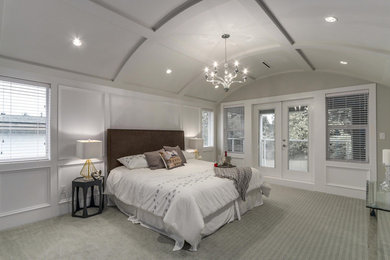 This is an example of a large transitional master bedroom in Vancouver with grey walls and carpet.