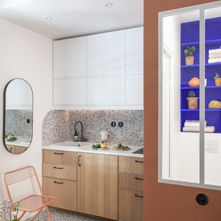 На фото: маленькие линейные кухни-гостиные в стиле модернизм с одинарной раковиной, фасадами с декоративным кантом, светлыми деревянными фасадами, столешницей из ламината, разноцветным фартуком, фартуком из керамической плитки, техникой под мебельный фасад, полом из терраццо, разноцветным полом и белой столешницей