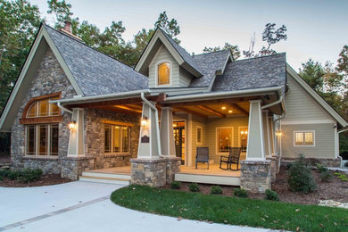 Large craftsman beige three-story stone exterior home idea in Other with a shingle roof
