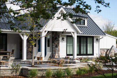 Large cottage white two-story mixed siding exterior home photo in Milwaukee with a metal roof