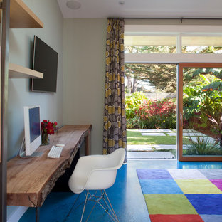 Diseño de despacho contemporáneo con paredes grises, suelo de cemento y suelo azul