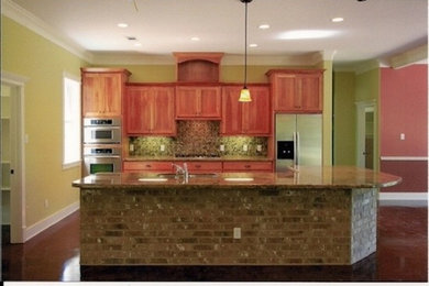 Large kitchen pantry photo in Austin with medium tone wood cabinets, granite countertops, stainless steel appliances and an island