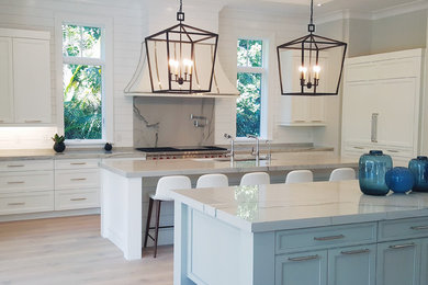 Inspiration for a transitional eat-in kitchen remodel in Miami with a double-bowl sink, shaker cabinets, white cabinets, stainless steel appliances, two islands and white countertops