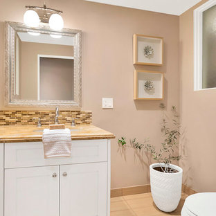 Idee per una stanza da bagno con doccia moderna di medie dimensioni con ante con bugna sagomata, ante bianche, doccia ad angolo, WC a due pezzi, piastrelle multicolore, piastrelle in pietra, pareti rosa, pavimento in cementine, lavabo sottopiano, top in granito, pavimento rosa, porta doccia a battente e top beige