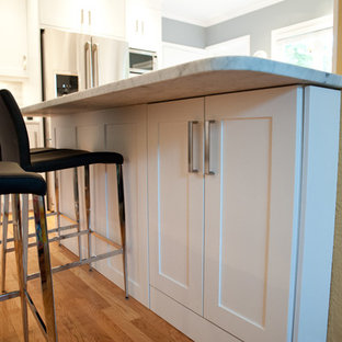 Mid-sized transitional kitchen pantry ideas - Mid-sized transitional u-shaped light wood floor and beige floor kitchen pantry photo in Vancouver with an undermount sink, shaker cabinets, white cabinets, marble countertops, gray backsplash, stainless steel appliances, a peninsula and stone tile backsplash