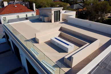 Deck - large modern rooftop rooftop glass railing deck idea in New York with a fire pit and no cover