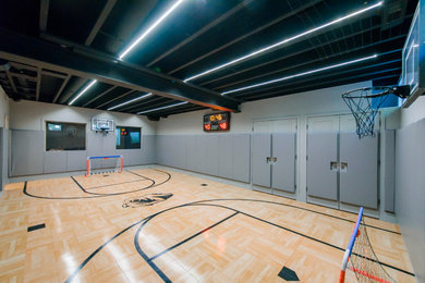 Großer Moderner Fitnessraum mit Indoor-Sportplatz, grauer Wandfarbe und hellem Holzboden in St. Louis