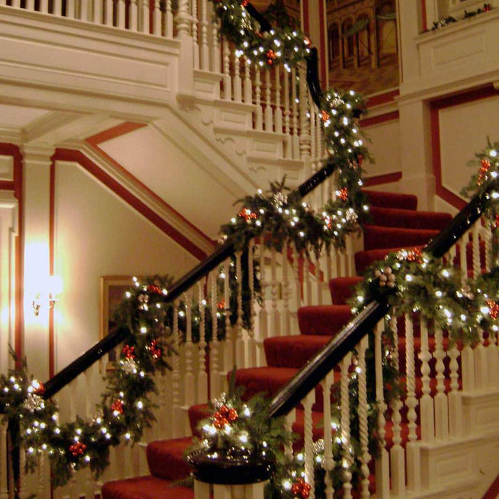 Holiday Decorations we set  up this staircase in Greenwich, CT. Pine Cones and red balls to tie in with the carpet of the stairs.