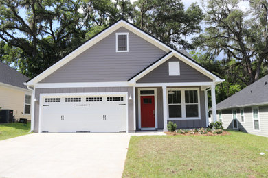 Example of a mid-sized arts and crafts gray two-story concrete fiberboard and clapboard exterior home design with a shingle roof and a black roof