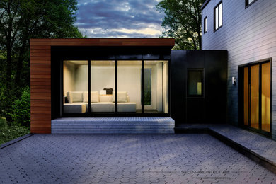 Design ideas for a mid-sized contemporary one-storey exterior in Montreal with wood siding and a flat roof.