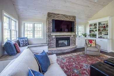 Mid-sized elegant enclosed porcelain tile family room photo in Other with beige walls, a standard fireplace, a stone fireplace and a wall-mounted tv