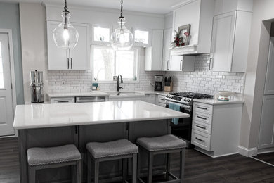 Large transitional vinyl floor and gray floor eat-in kitchen photo in Detroit with a farmhouse sink, shaker cabinets, white cabinets, quartzite countertops, white backsplash, subway tile backsplash, stainless steel appliances, an island and white countertops